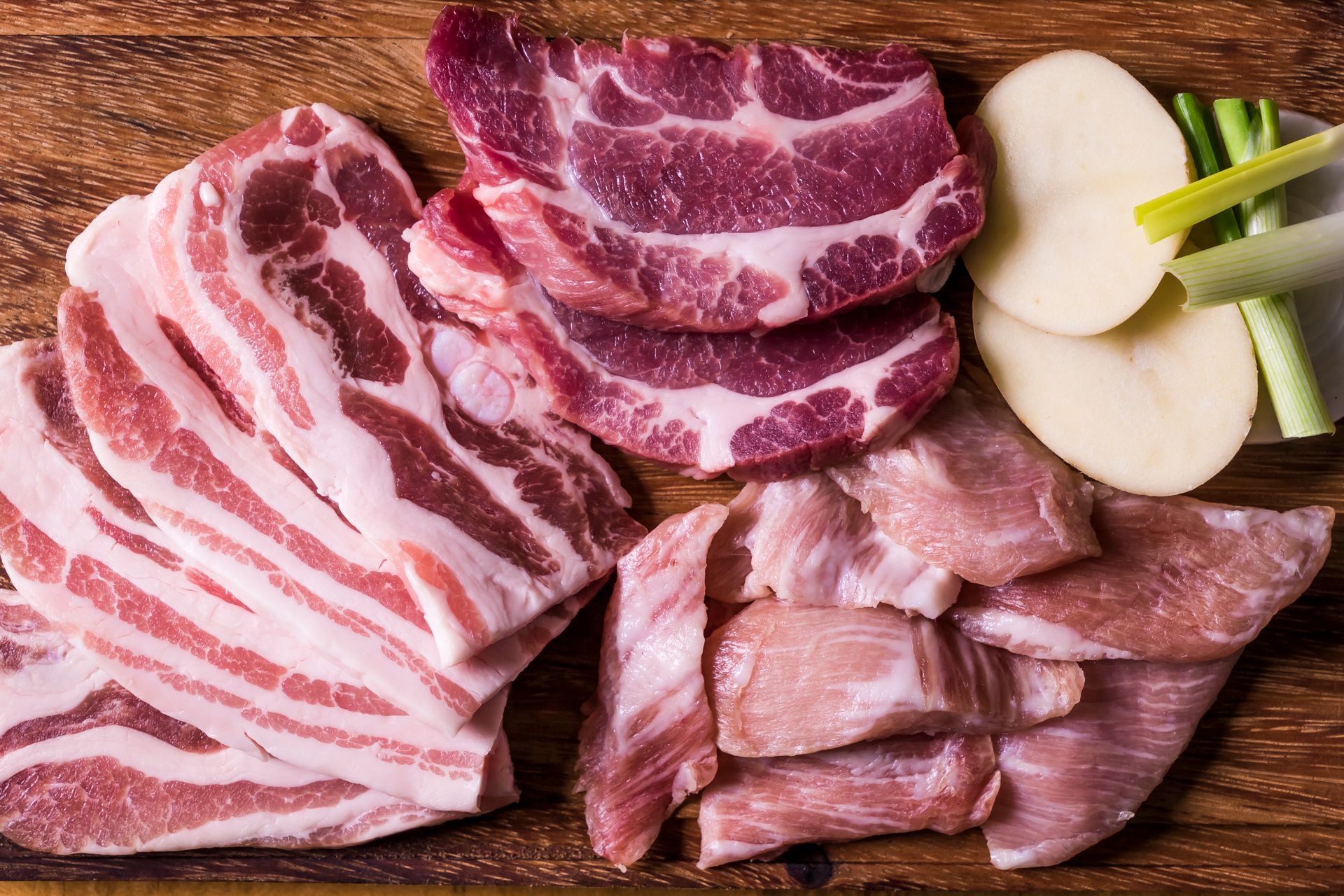 A variety of fresh pork cuts on a wooden board